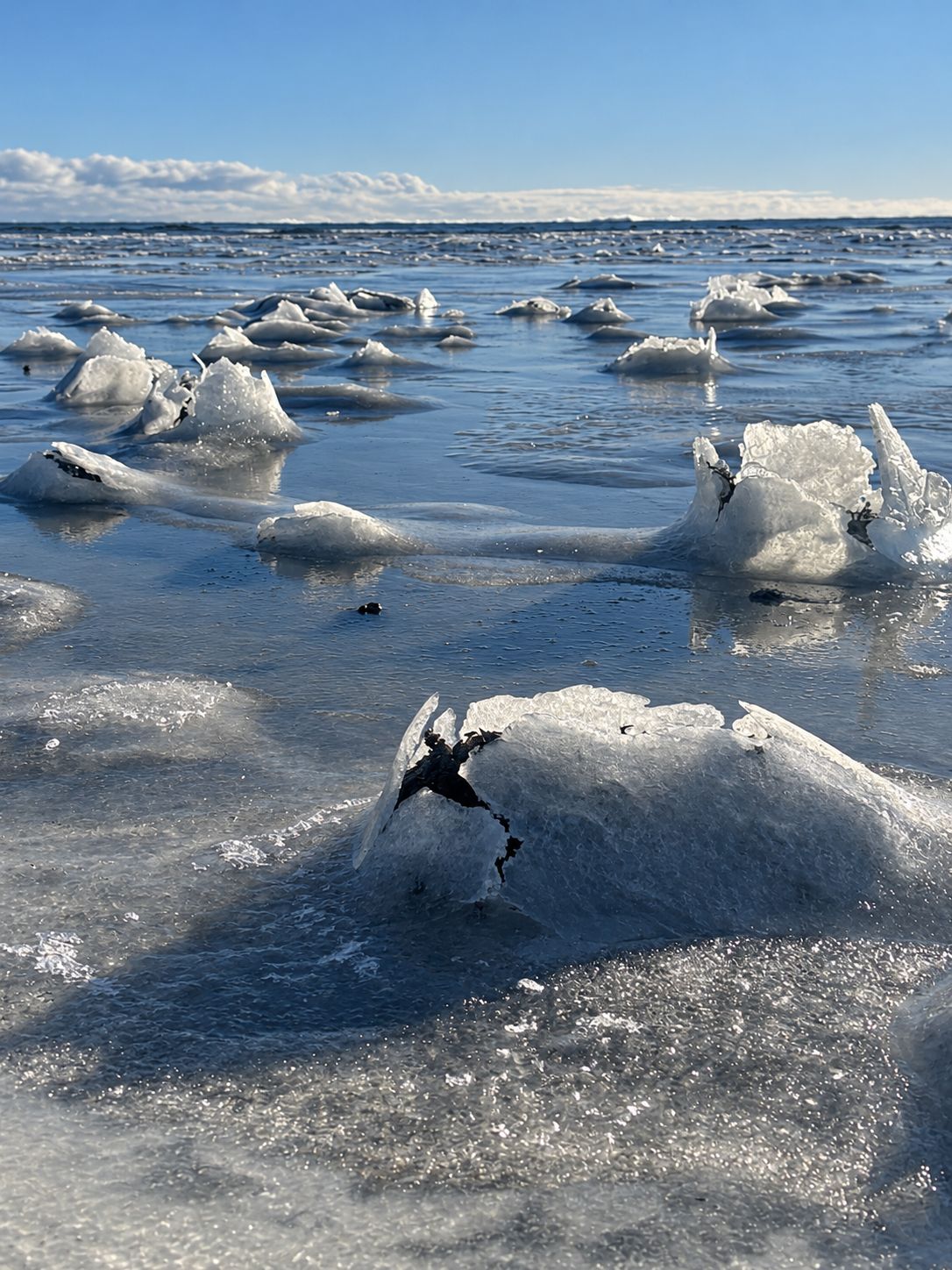 Lac gelé parsemé de blocs de glace sous un ciel bleu
