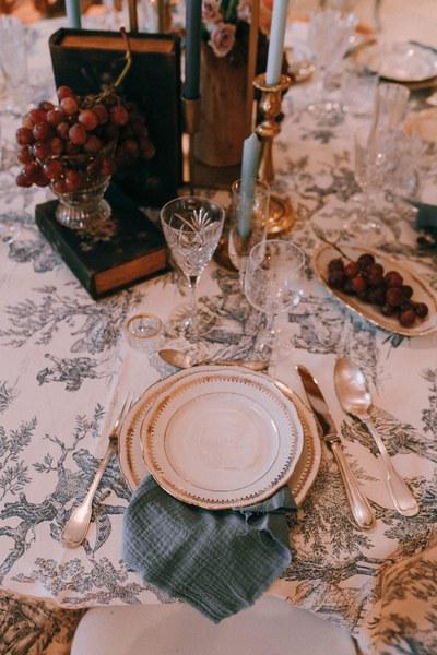 Table de mariage dressée avec soin : assiettes, verres, bougies et serviette en lin