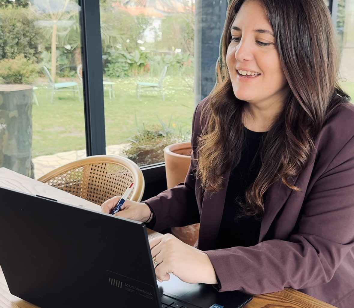 Camille, wedding planner, souriante devant son ordinateur portable